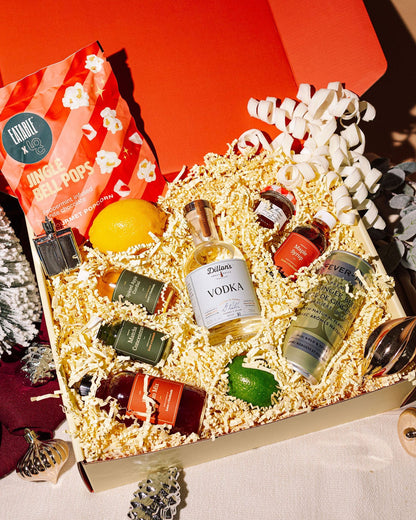 Gift box with miniature bottles and decorative items on a festive background
